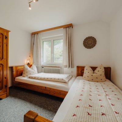 Helles Kleines Schlafzimmer der Ferienwohnung Mittagspitze im Haus Wilma, zwei Einzelbetten, und Holzschrank